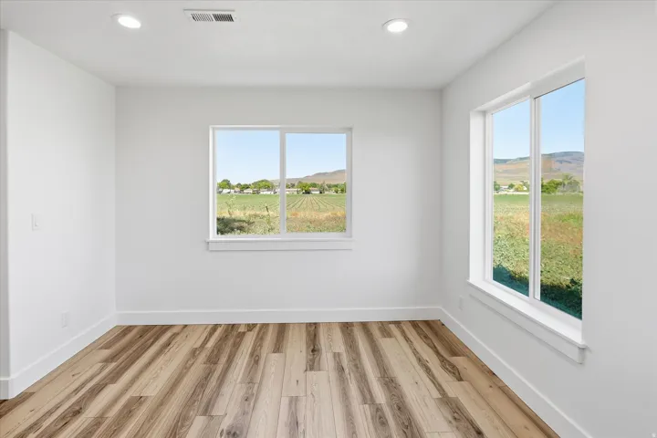 Bright room featuring wood-finish flooring and recessed lighting