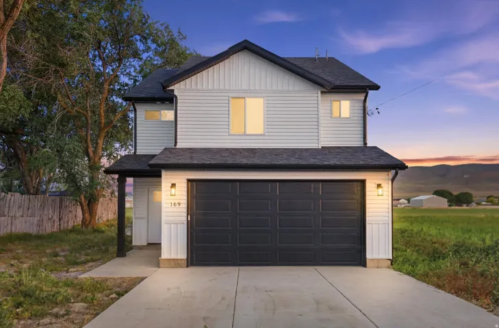 Two-story residence featuring light-colored siding and a dark roof