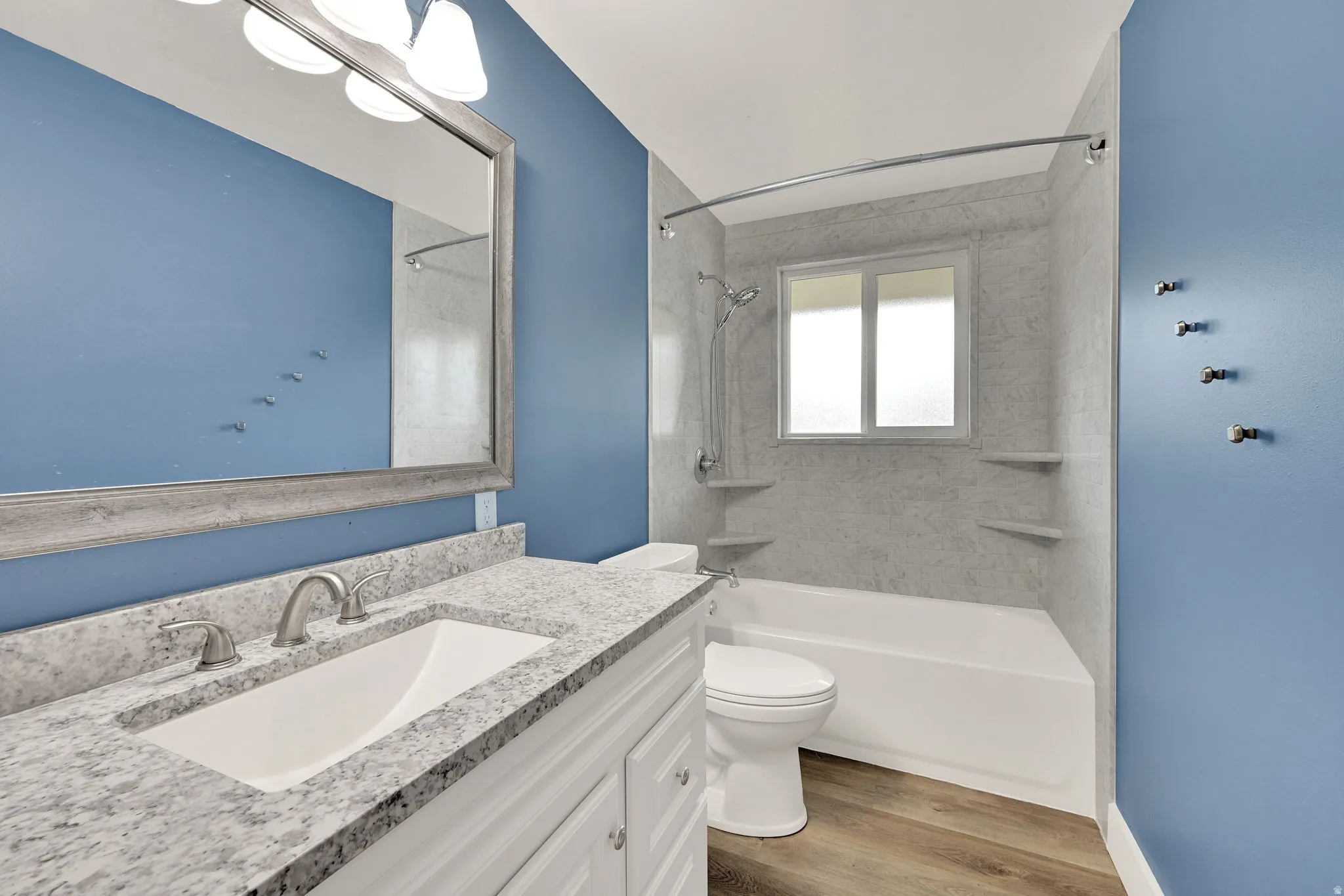 Bathroom featuring a white vanity with a granite-style countertop and an undermount sink