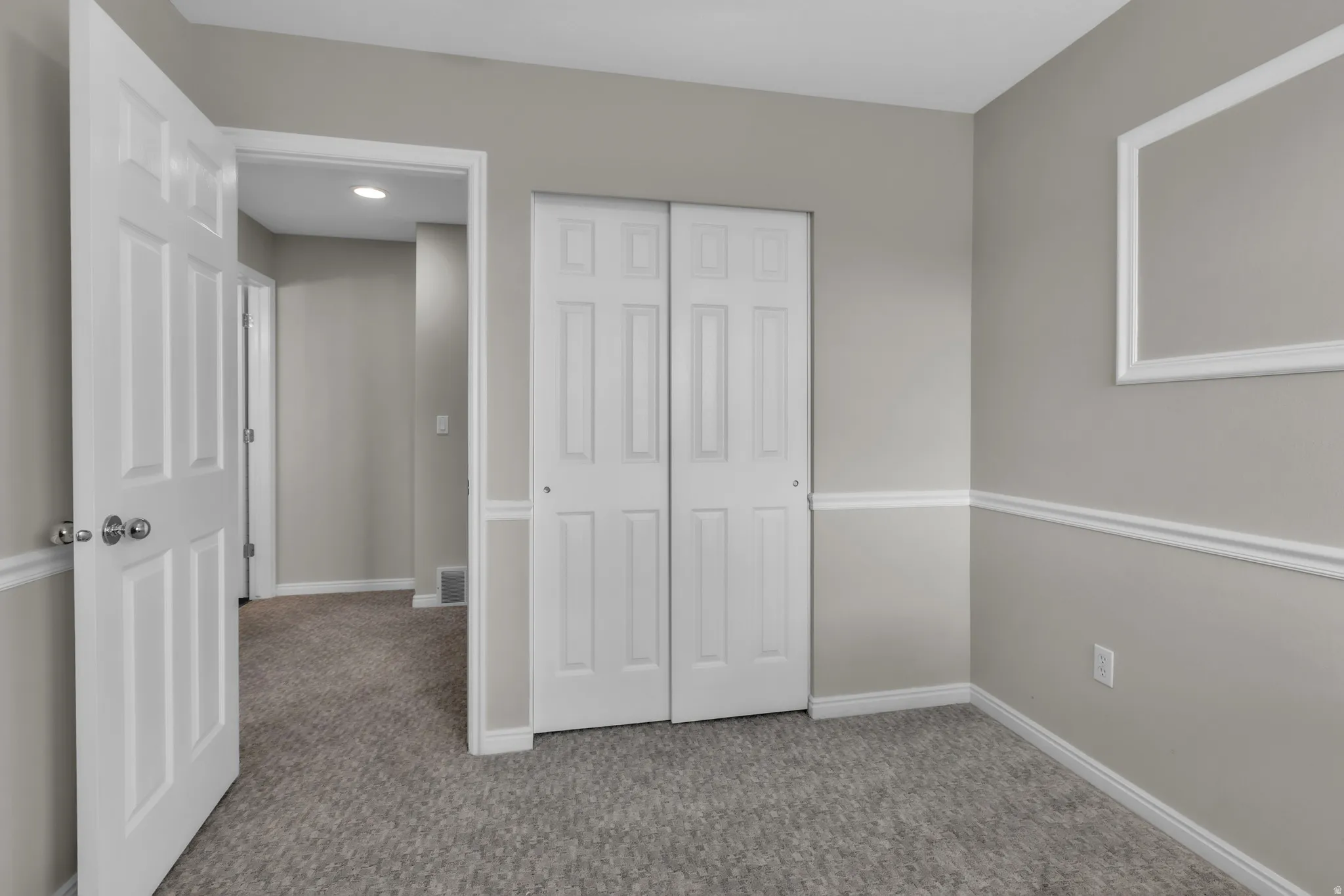 Room featuring light gray wall paint, white trim, and gray carpeting