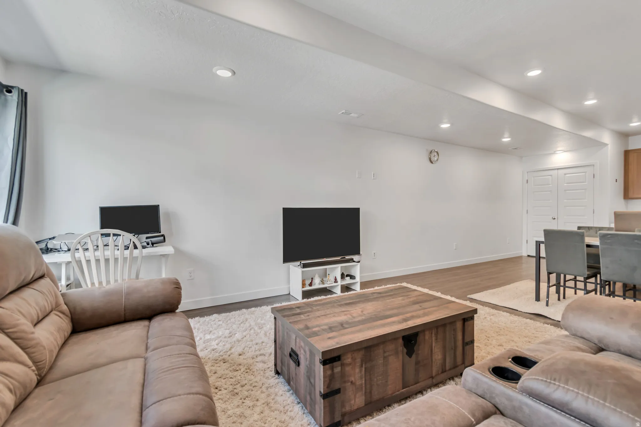 Open-concept living space featuring recessed lighting, light wood-finish flooring, white baseboards, and white walls