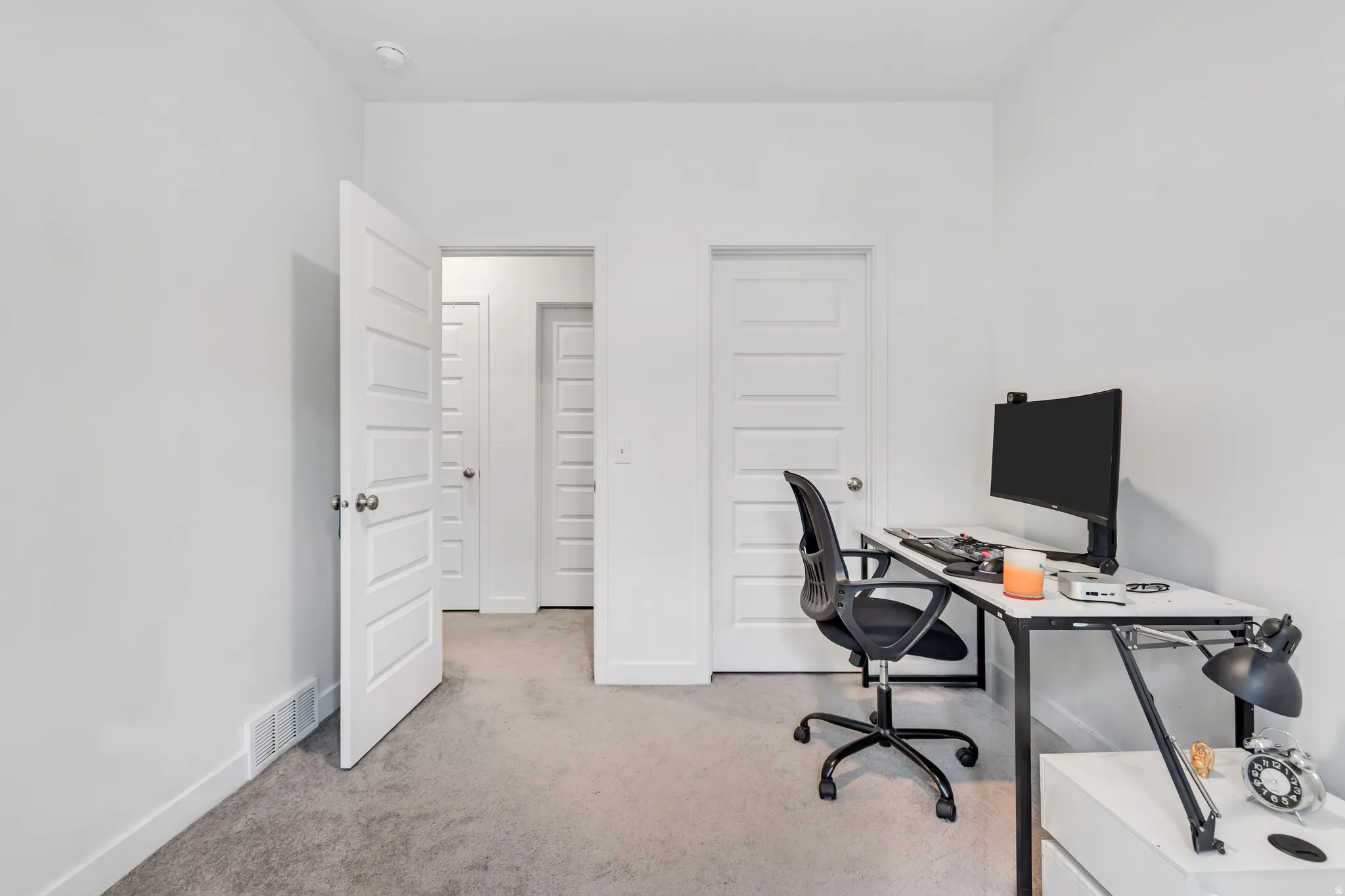 Neutral color palette room featuring light gray carpeting and white painted walls