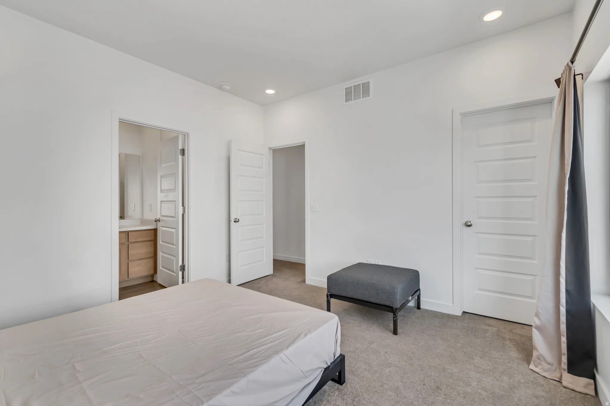Carpeted room with recessed lighting and a window featuring a curtain rod