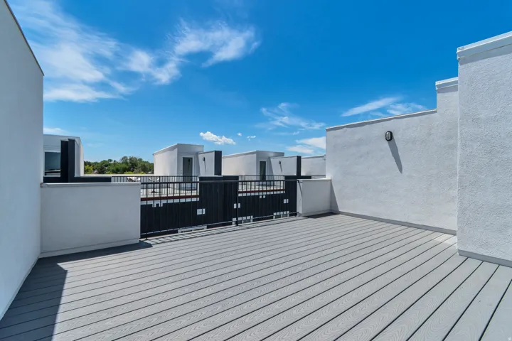 Rooftop deck featuring composite decking and white stucco walls