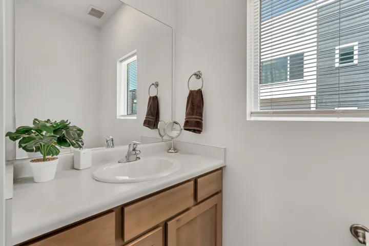 Bathroom vanity featuring a white countertop, an undermount sink, and a chrome faucet