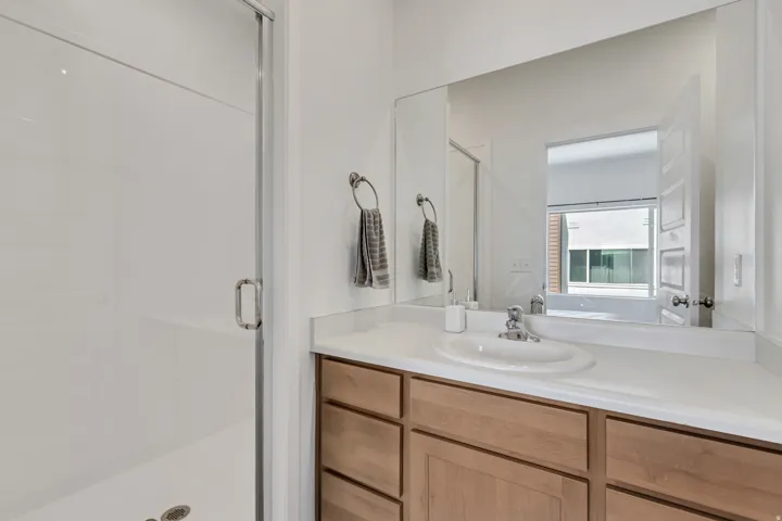 Bathroom featuring a light wood-finish vanity with an integrated sink and a neutral-toned countertop