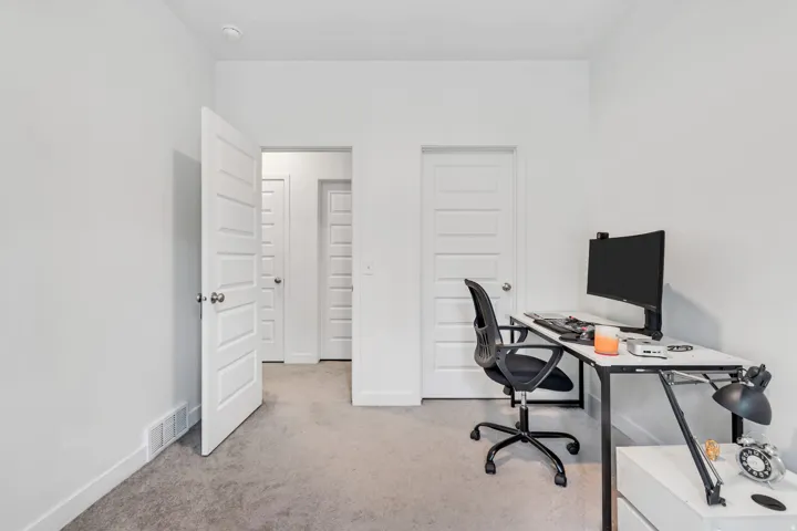 Neutral color palette room featuring light gray carpeting and white painted walls