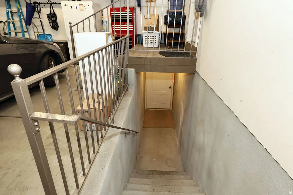Stairwell featuring concrete steps and a white paneled door