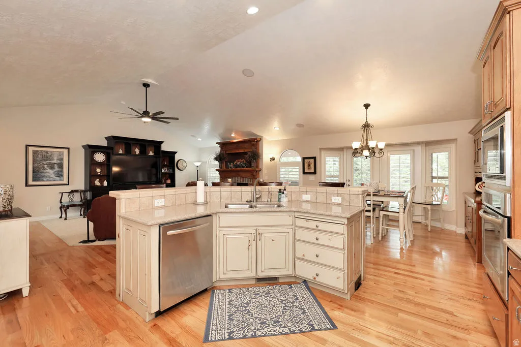 Kitchen island featuring light-toned cabinetry, light-toned countertop, and stainless steel dishwasher