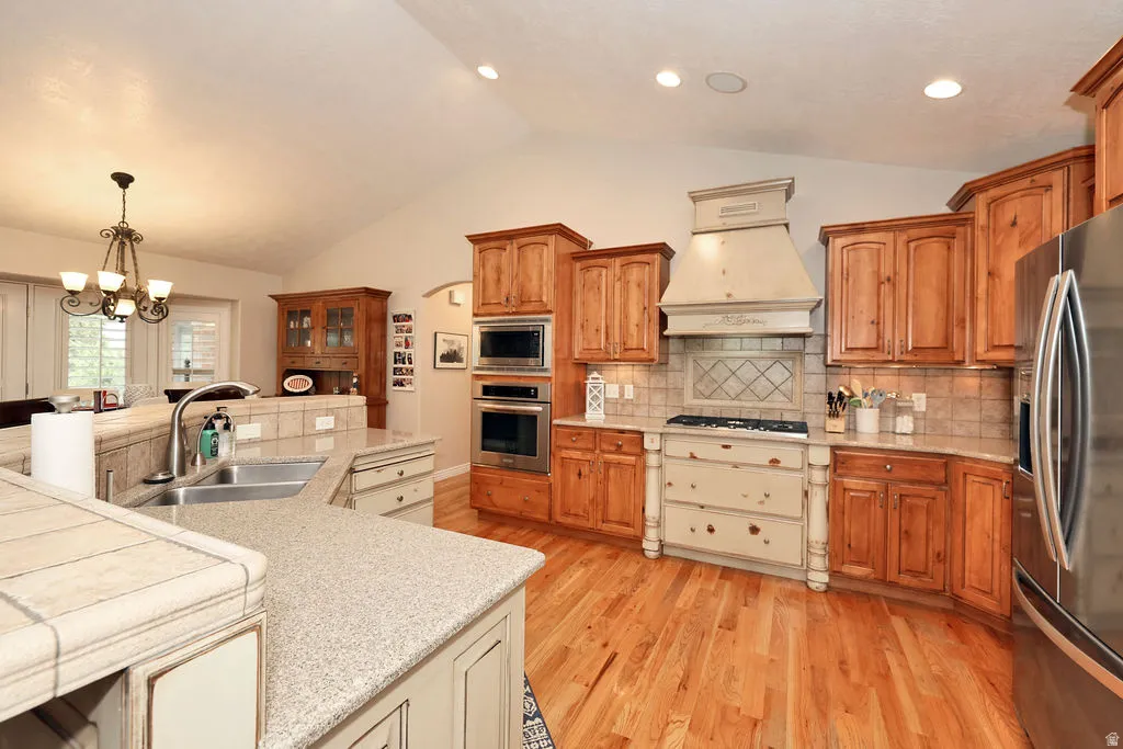 Kitchen featuring wood-finish flooring, vaulted ceiling, and recessed lighting