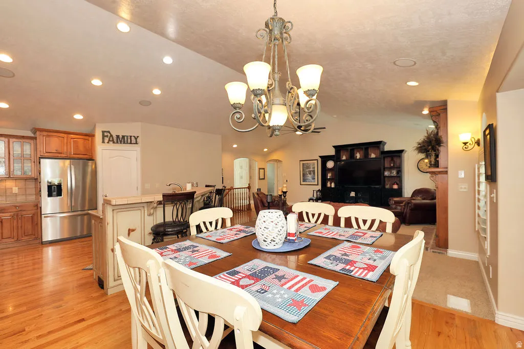 Dining area featuring a wood-finish table, a decorative chandelier, and recessed lighting
