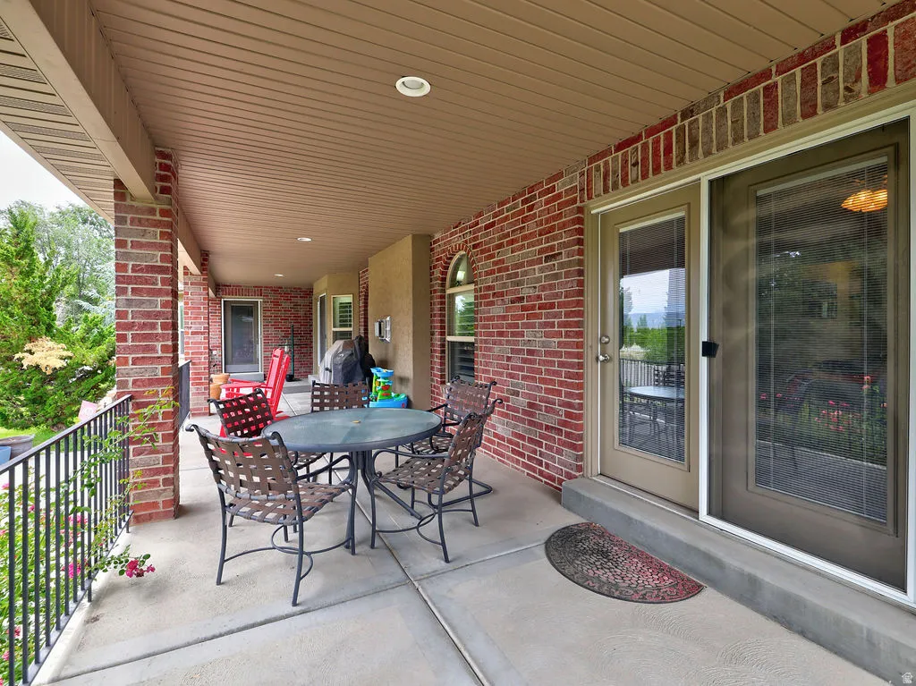 Covered patio featuring a concrete surface, brick pillars, and a ceiling with recessed lighting