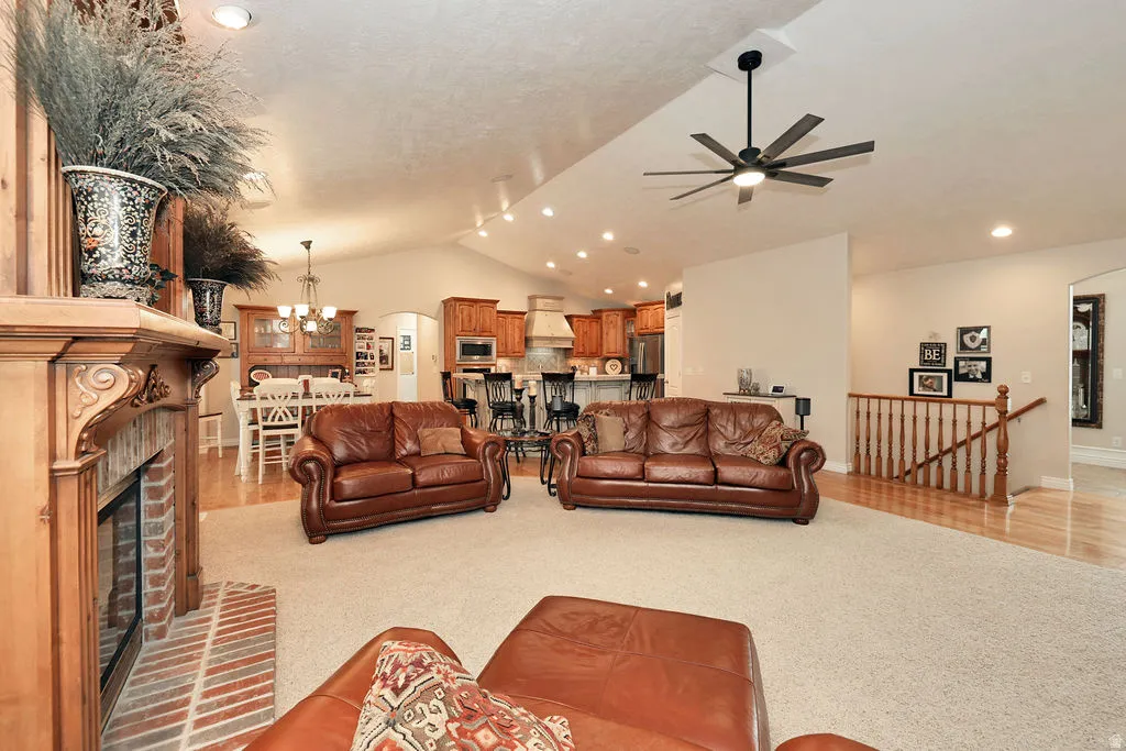 Spacious living area featuring a vaulted ceiling with recessed lighting and a ceiling fan