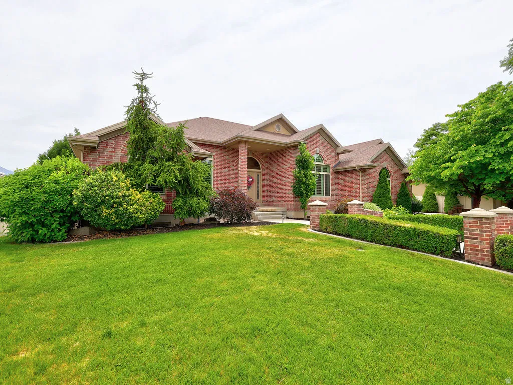 Red brick exterior featuring arched windows, a covered entryway, and a prominent front gable