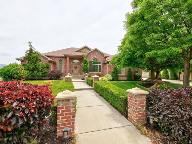 Brick exterior facade featuring arch-top windows, an arched entry, and a covered porch