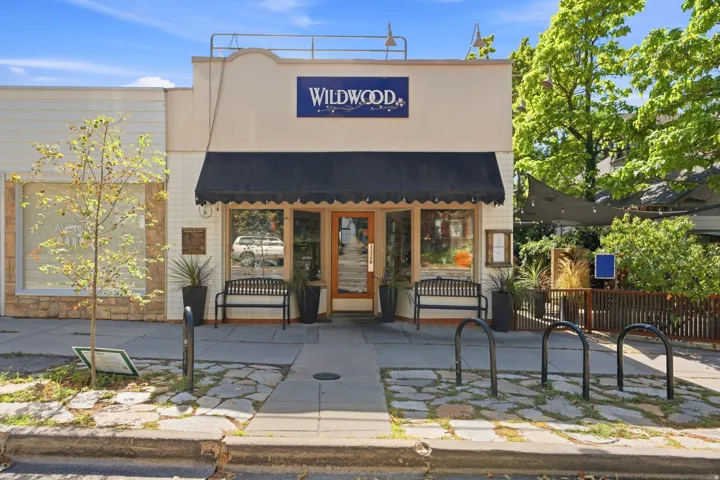 Commercial storefront featuring a black awning, display windows, and an entrance with a glass door