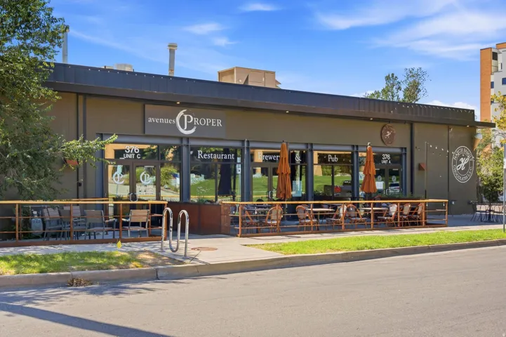 Commercial building with a dark facade, large storefront windows, and a black overhang