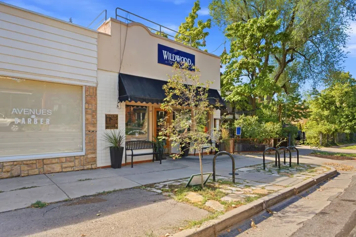 Mixed-use commercial building featuring a stone veneer facade, horizontal siding, and a prominent storefront with an awning