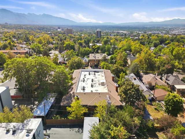 Residential neighborhood with mature trees and mountain backdrop