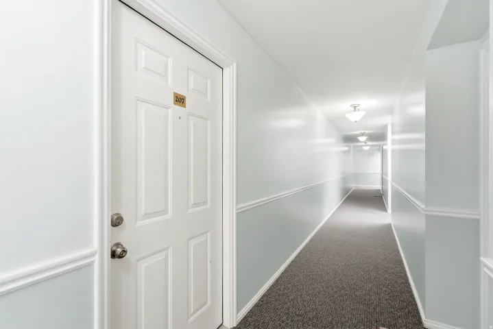Long hallway featuring recessed lighting and carpet flooring