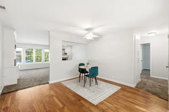 Wood-finish flooring, white painted walls, ceiling fan, carpeted areas, and built-in white cabinetry