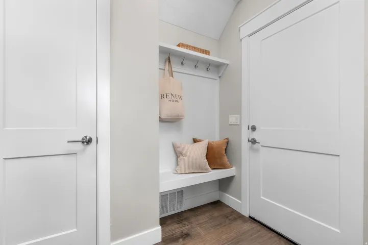 Integrated mudroom bench with storage, featuring wall-mounted hooks and an overhead shelf