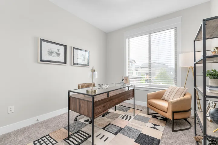 Carpeted room with a large window featuring horizontal blinds