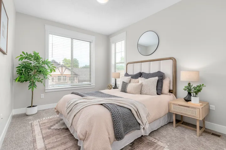 Spacious room featuring light-colored walls, carpeted flooring, and a large window with blinds
