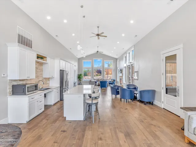 Open-concept living space featuring wood-finish flooring and a vaulted ceiling