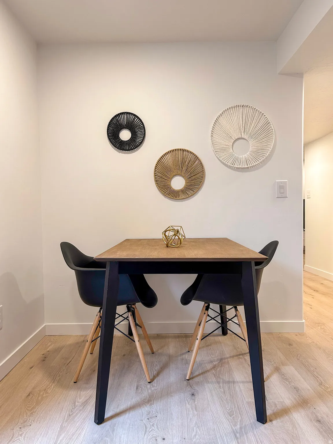 White wall with light-colored wood-finish flooring