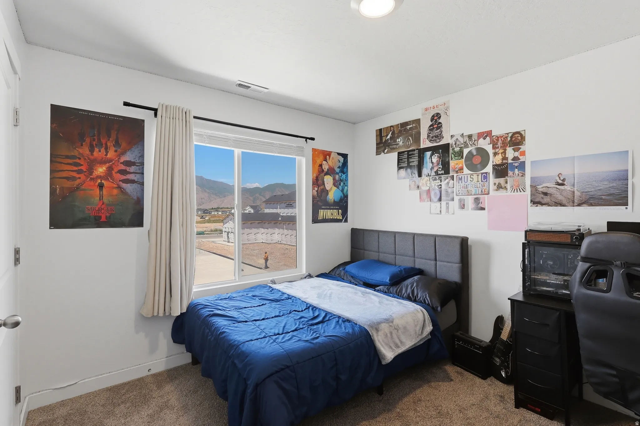 Bedroom featuring a large window, carpeted flooring, and a flush-mount ceiling light