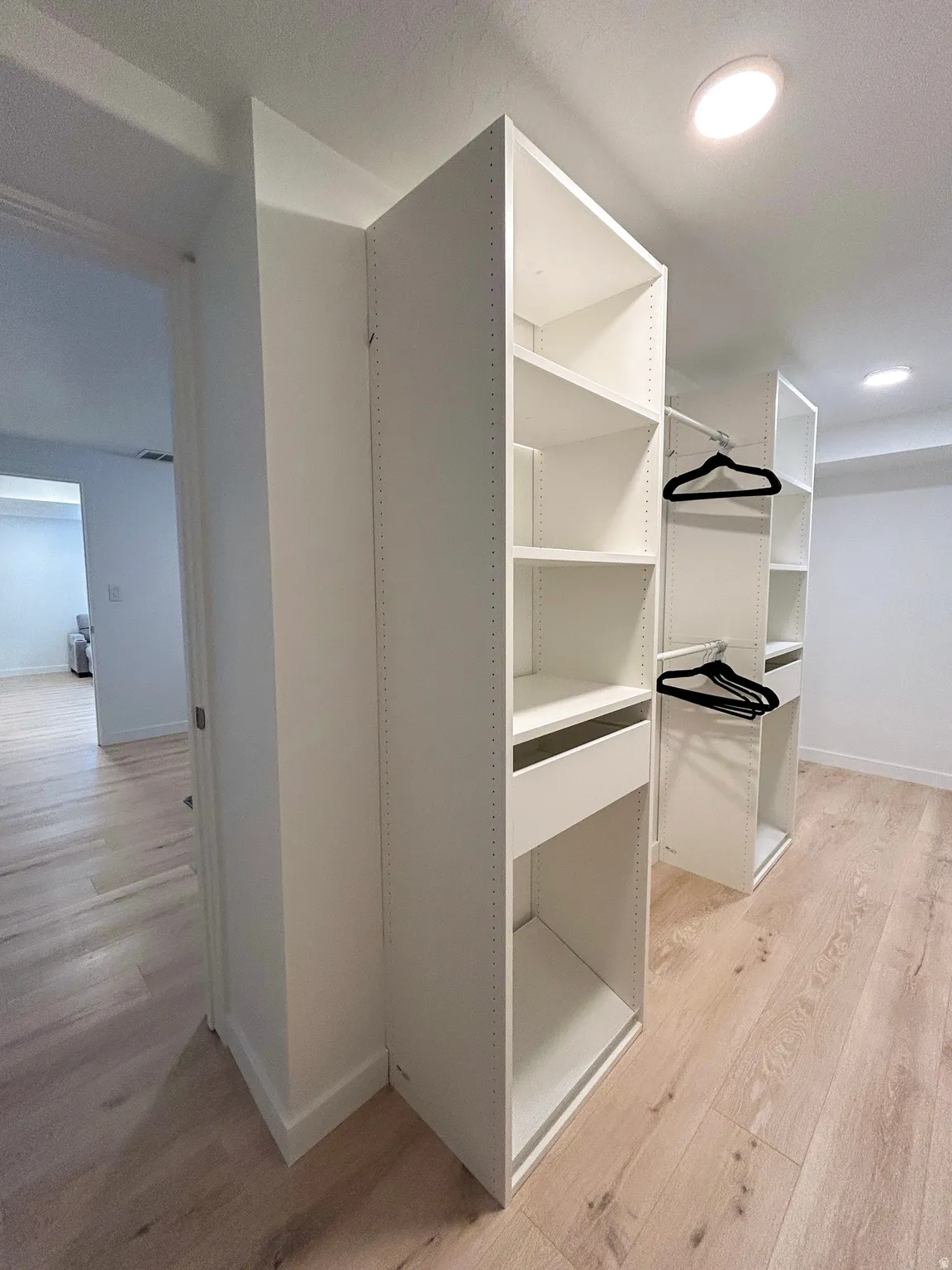 Custom white closet system featuring shelving and a built-in drawer