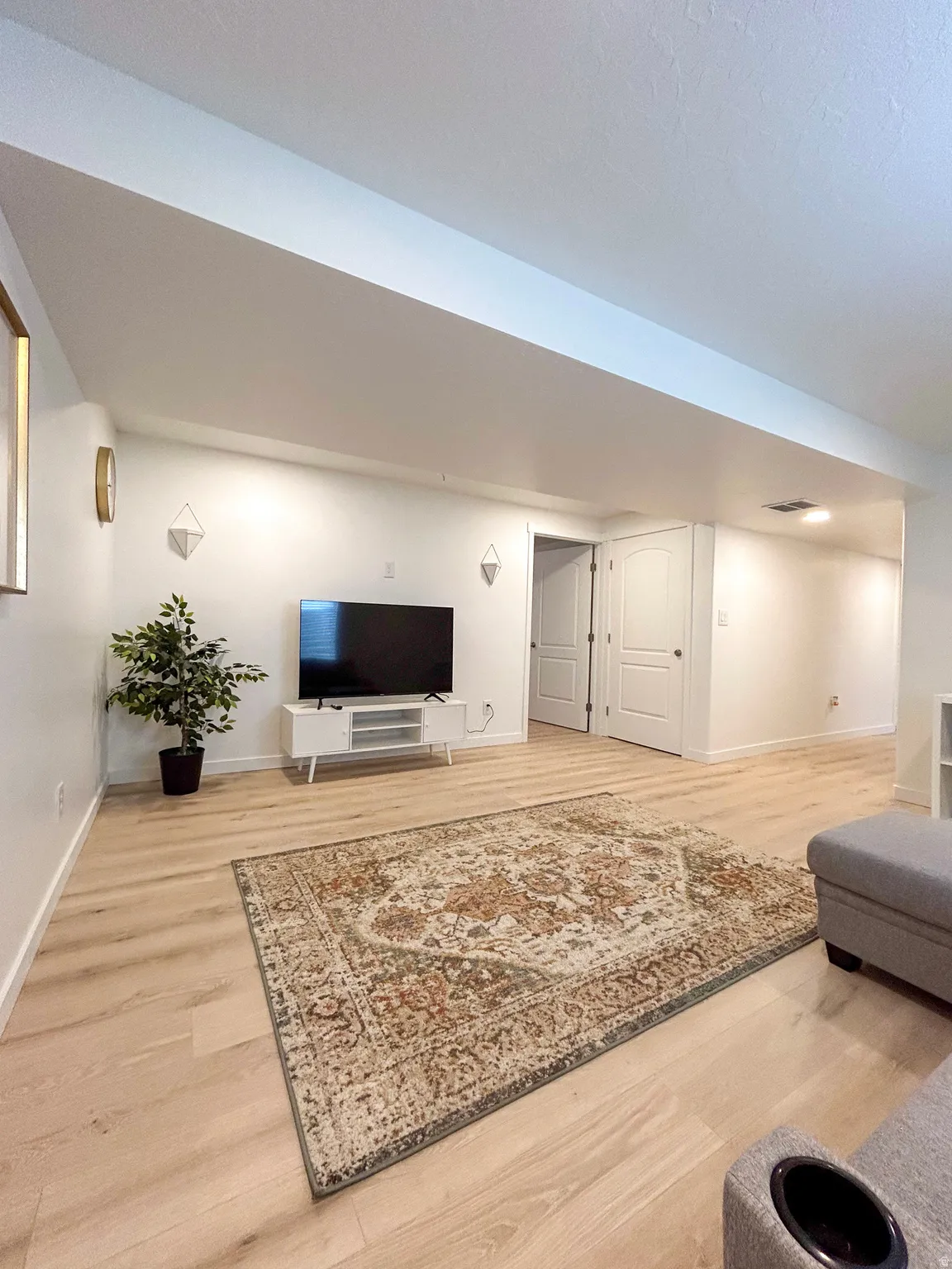 Spacious interior featuring light wood-finish flooring, white walls, and a recessed ceiling light