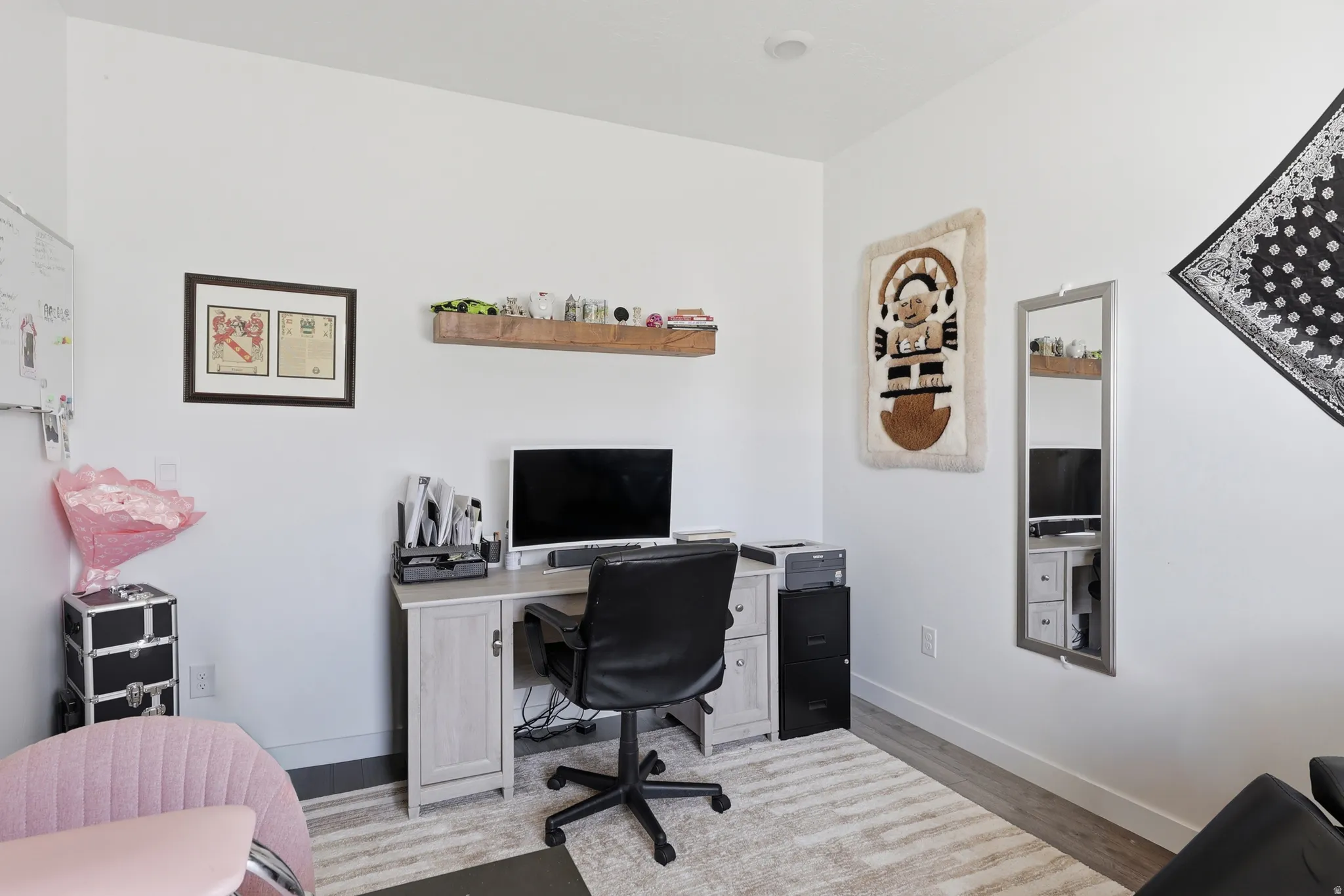 Dedicated workspace featuring wood-finish flooring and crisp white walls