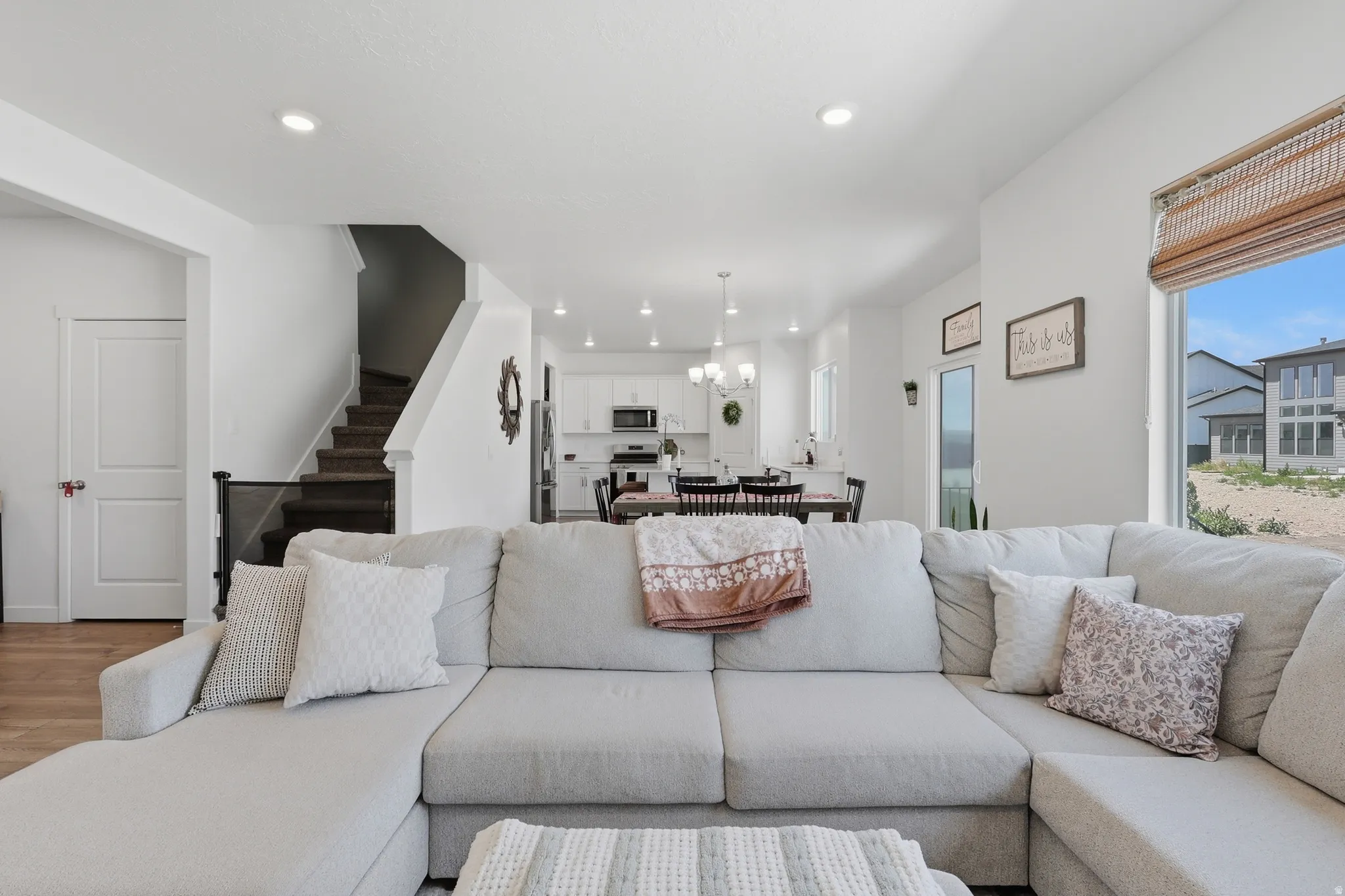 Open-concept living space with recessed lighting, wood-finish flooring, and a large window providing ample natural light