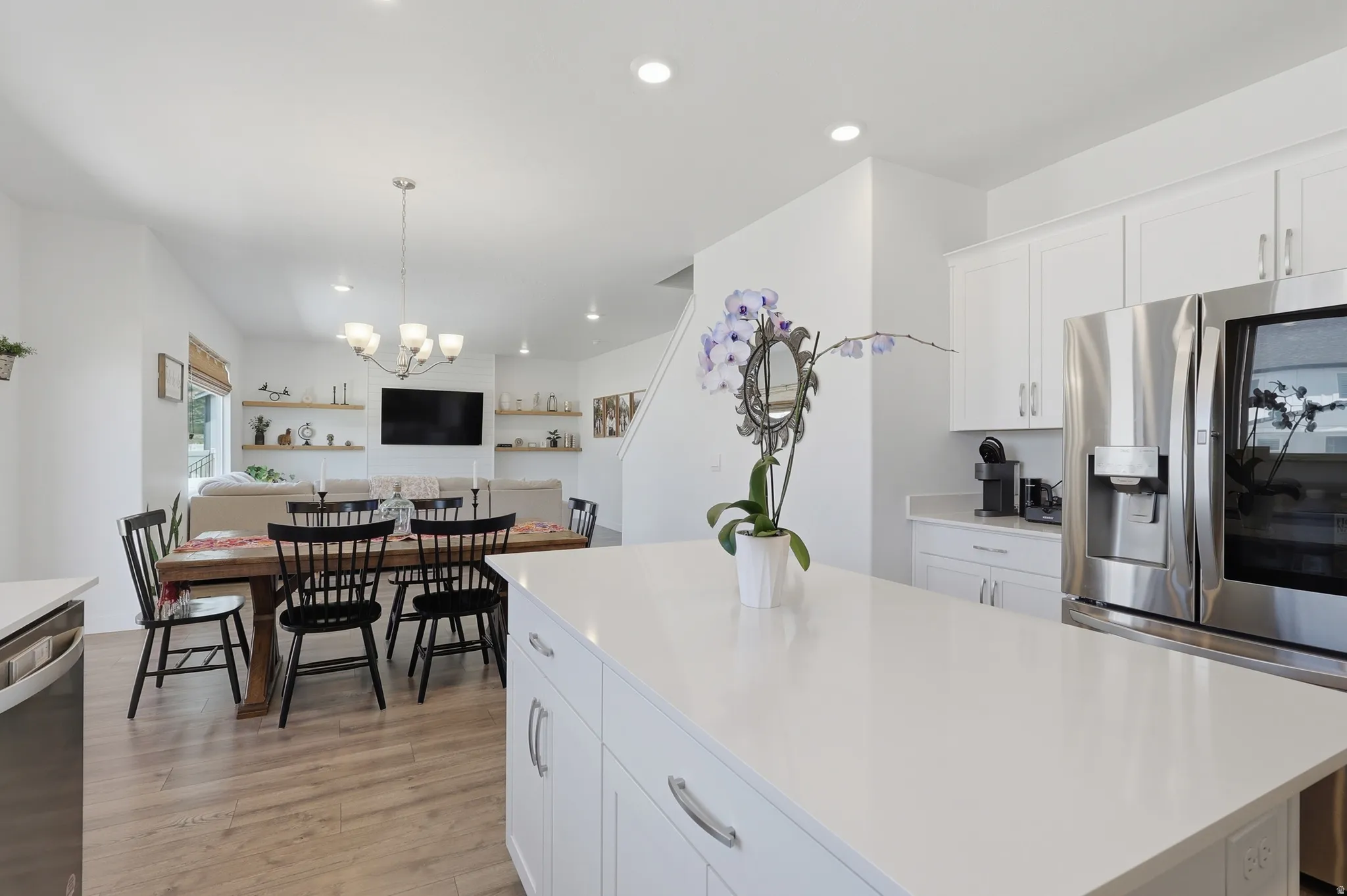 Spacious kitchen island with a white countertop, white cabinetry, and stainless steel appliances