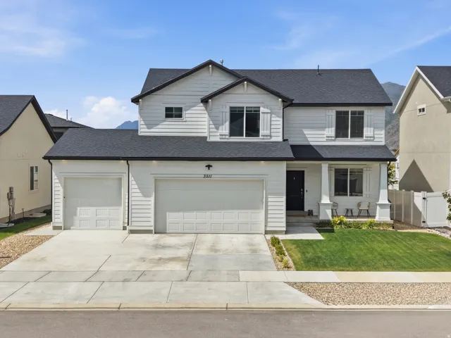 Contemporary two-story residence featuring white siding and a dark shingle roof