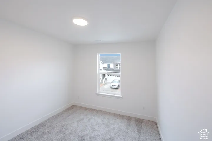 Neutral-toned carpeted flooring, white wall finishes, single-pane window with sill, and flush-mount ceiling lighting