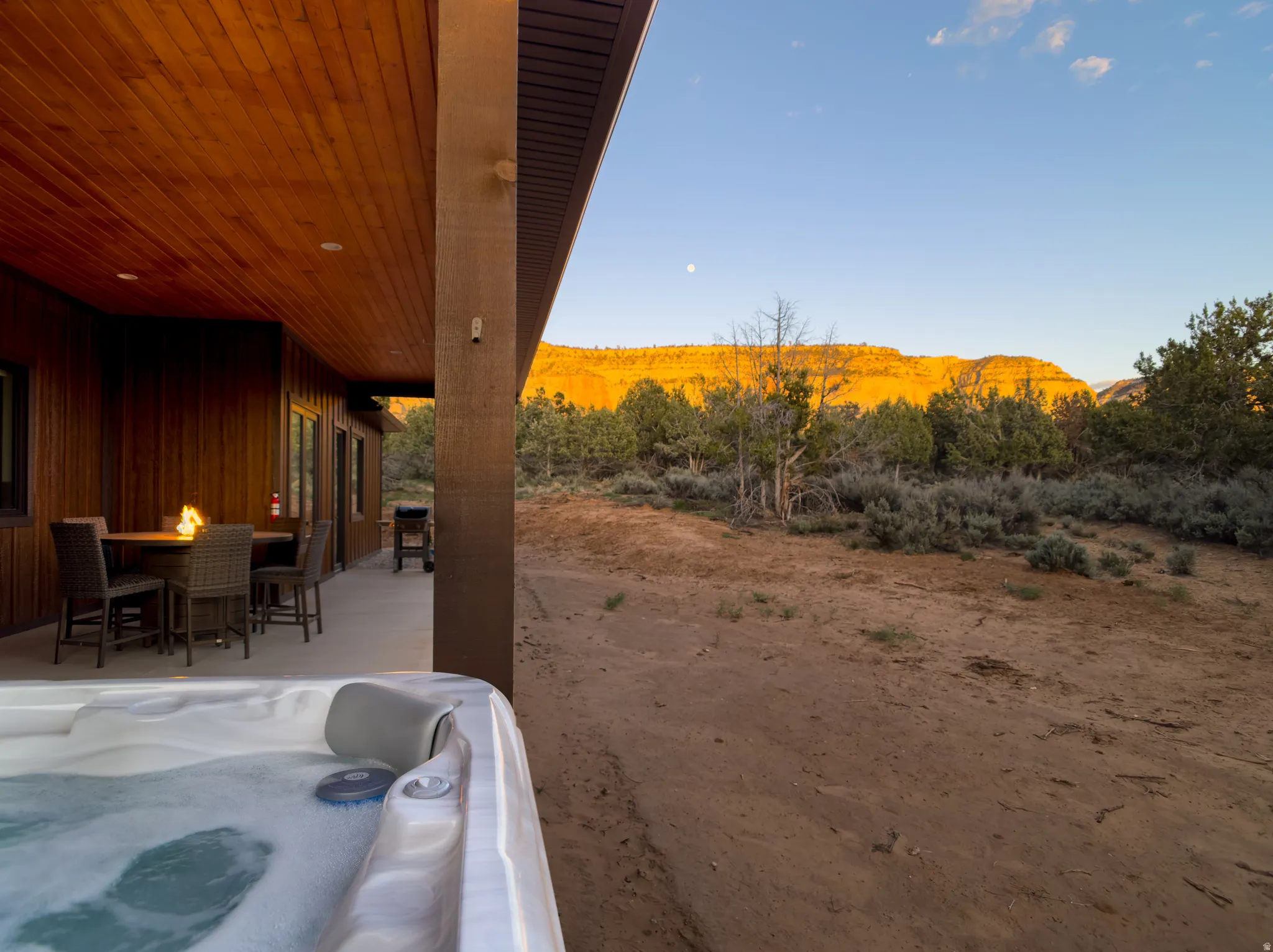 Covered patio featuring a hot tub and an outdoor dining area