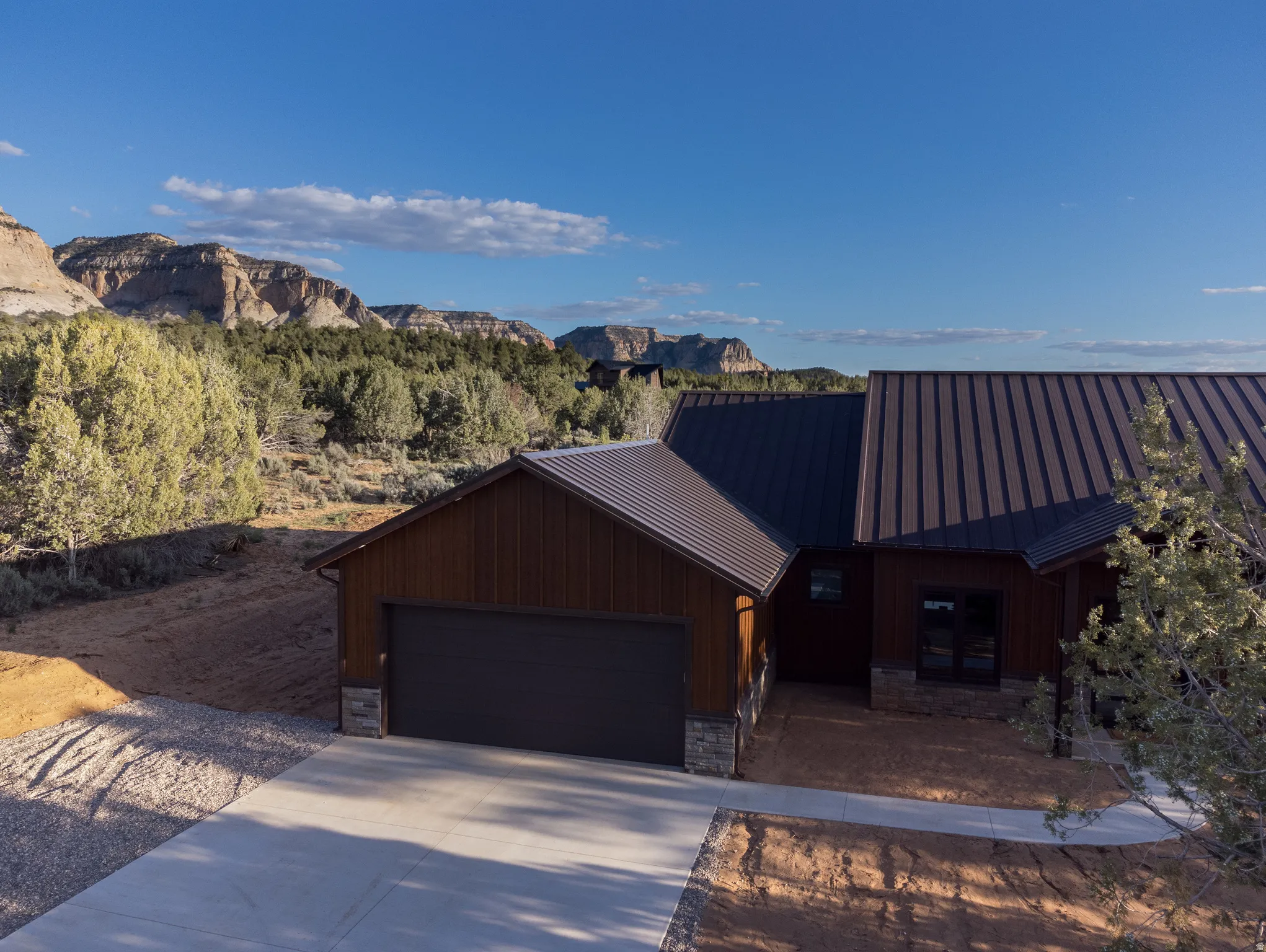Contemporary exterior with a metal roof, dark wood siding, and stone accents