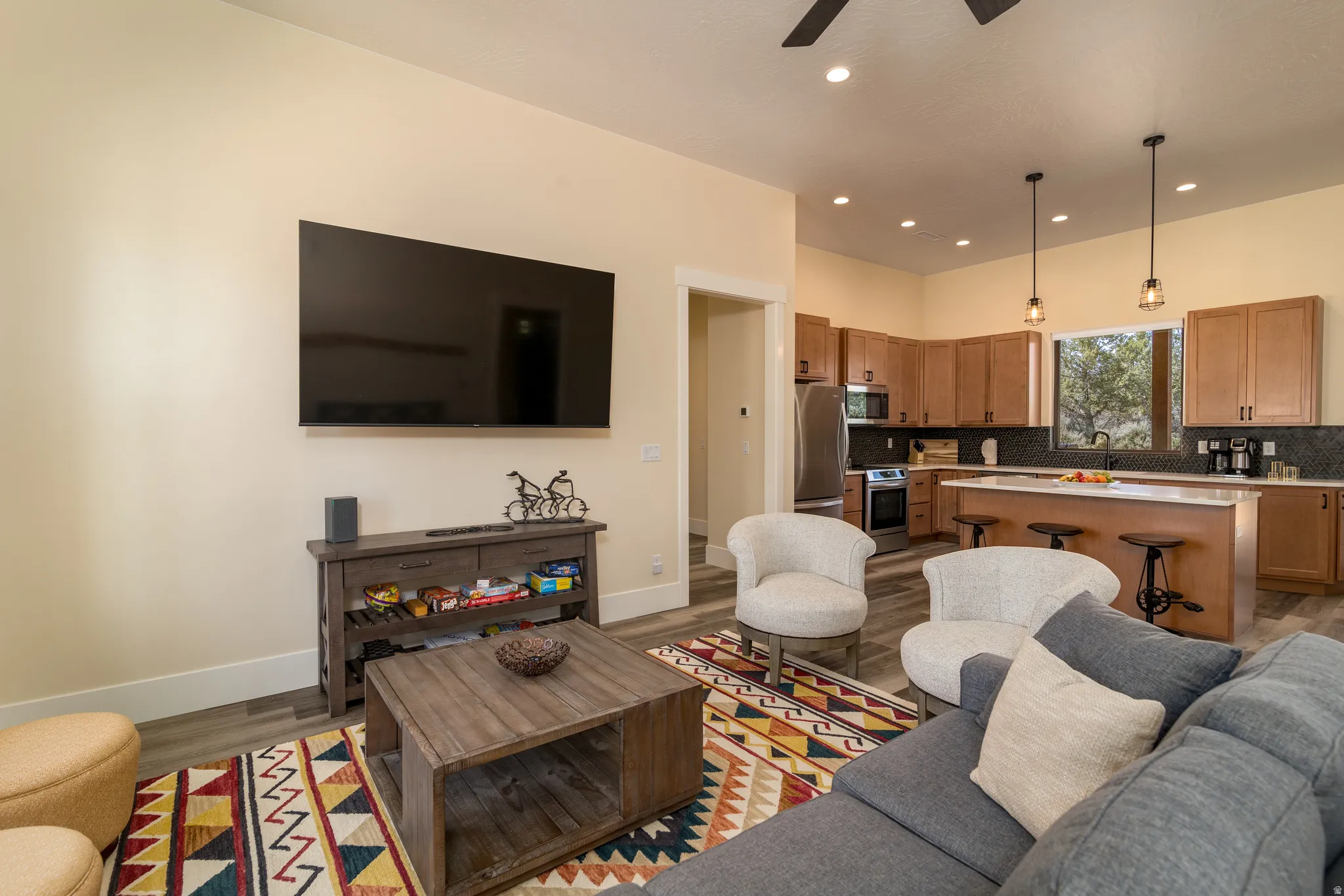 Spacious open-concept living area featuring wood-finish flooring, recessed lighting, and a ceiling fan