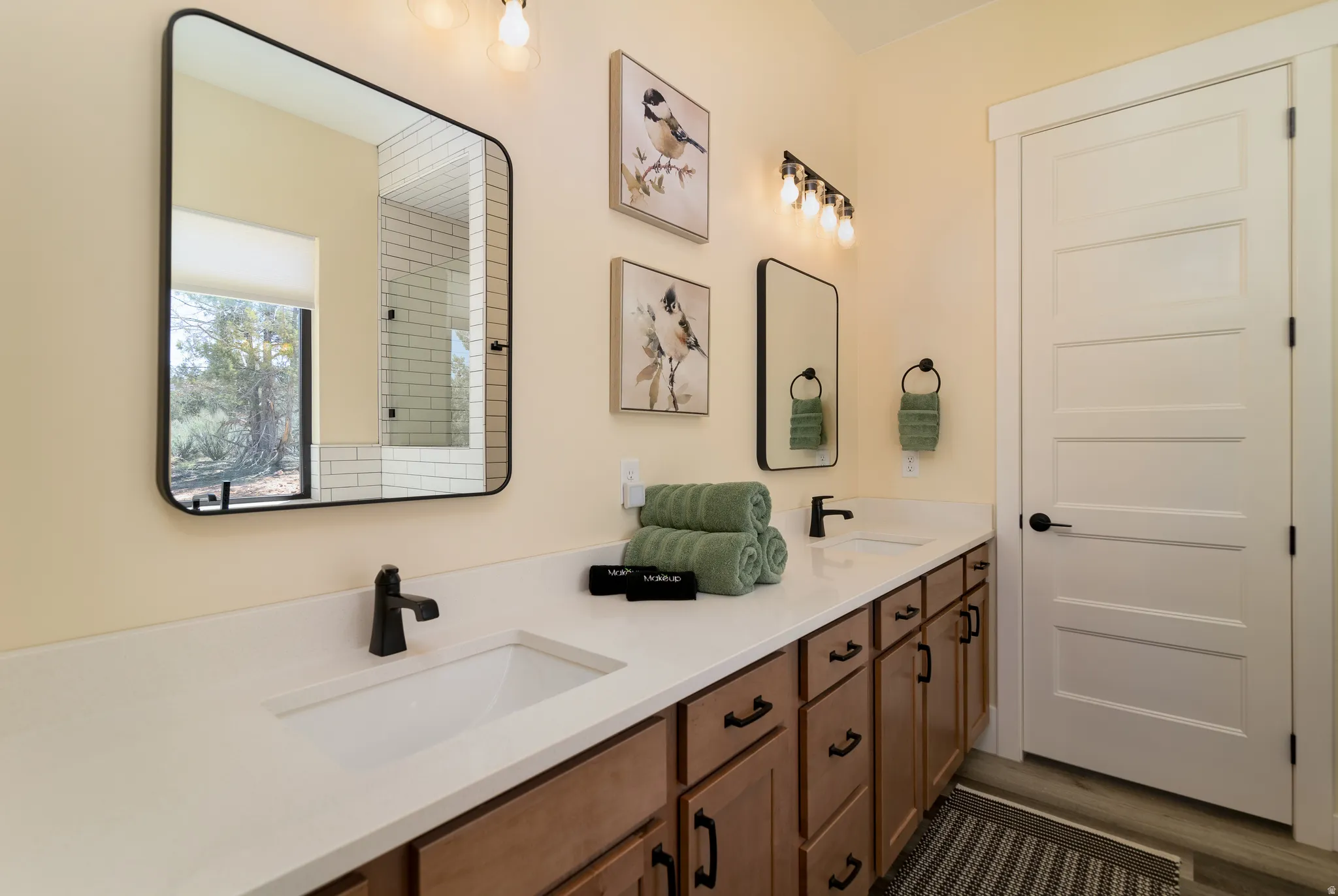 Primary bathroom with double vanity with integrated sinks and matte black fixtures