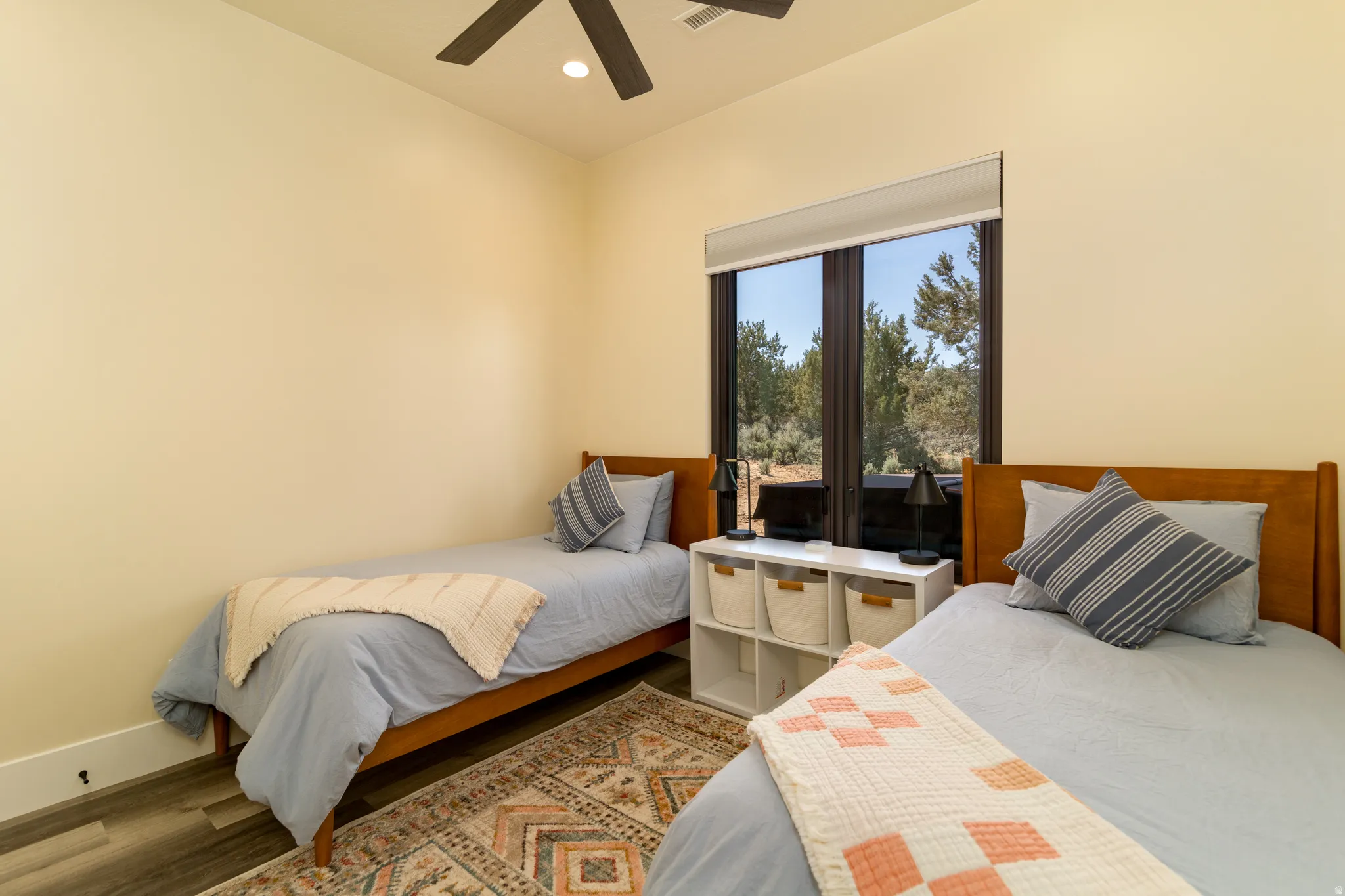 Bedroom 3 with wood-finish flooring, a large window, and a ceiling fan