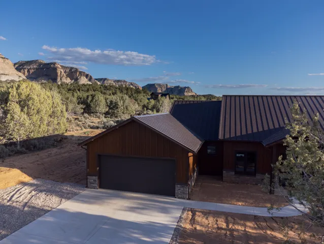 Contemporary exterior with a metal roof, dark wood siding, and stone accents