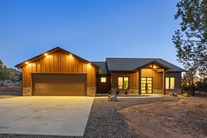 Modern exterior featuring wood paneling, stone accents, and a metal roof
