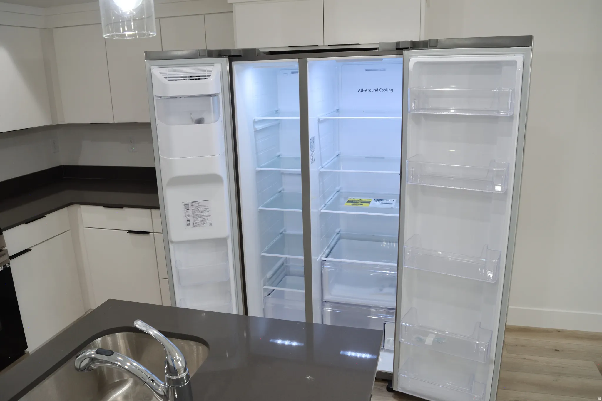 Side-by-side refrigerator featuring interior shelving and door storage