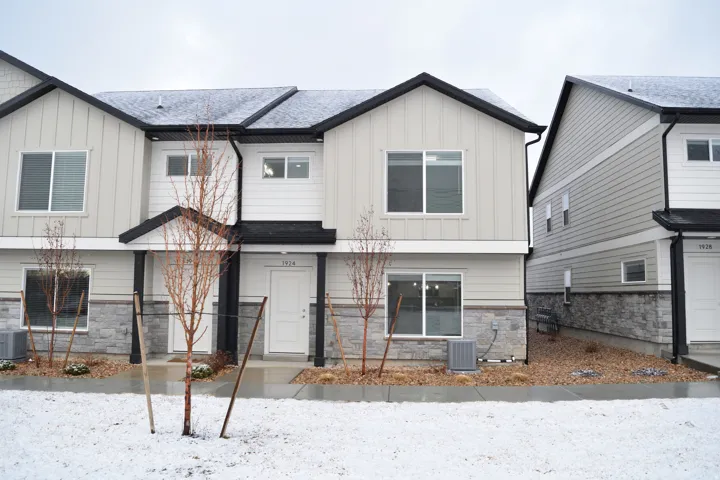 Modern townhome exterior with light-colored siding and dark trim accents