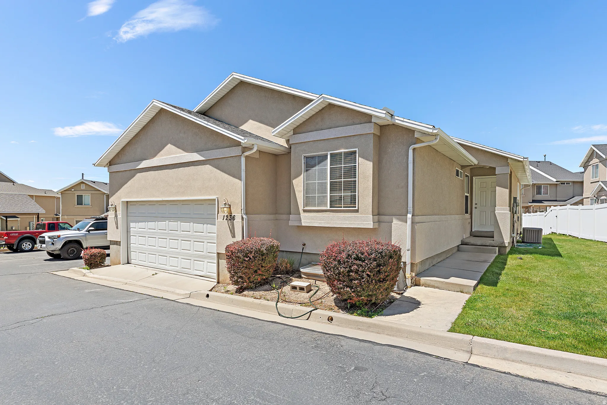 Stucco exterior with an attached garage, a side entrance, and a white paneled door