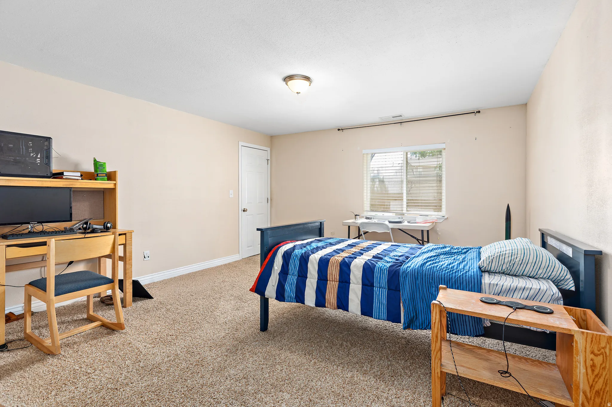 Neutral-toned walls complement the textured carpet flooring