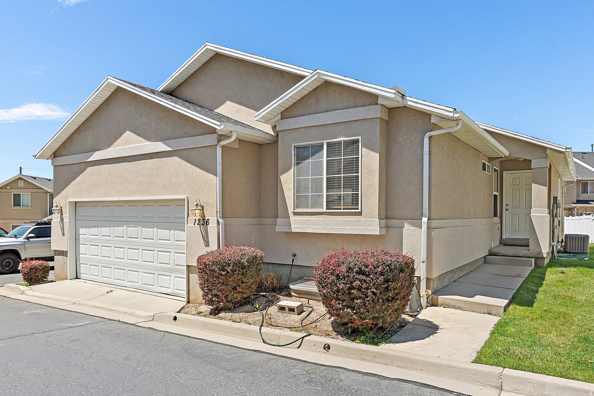 Stucco exterior with a pitched roofline, an attached single-car garage, and a front entry door